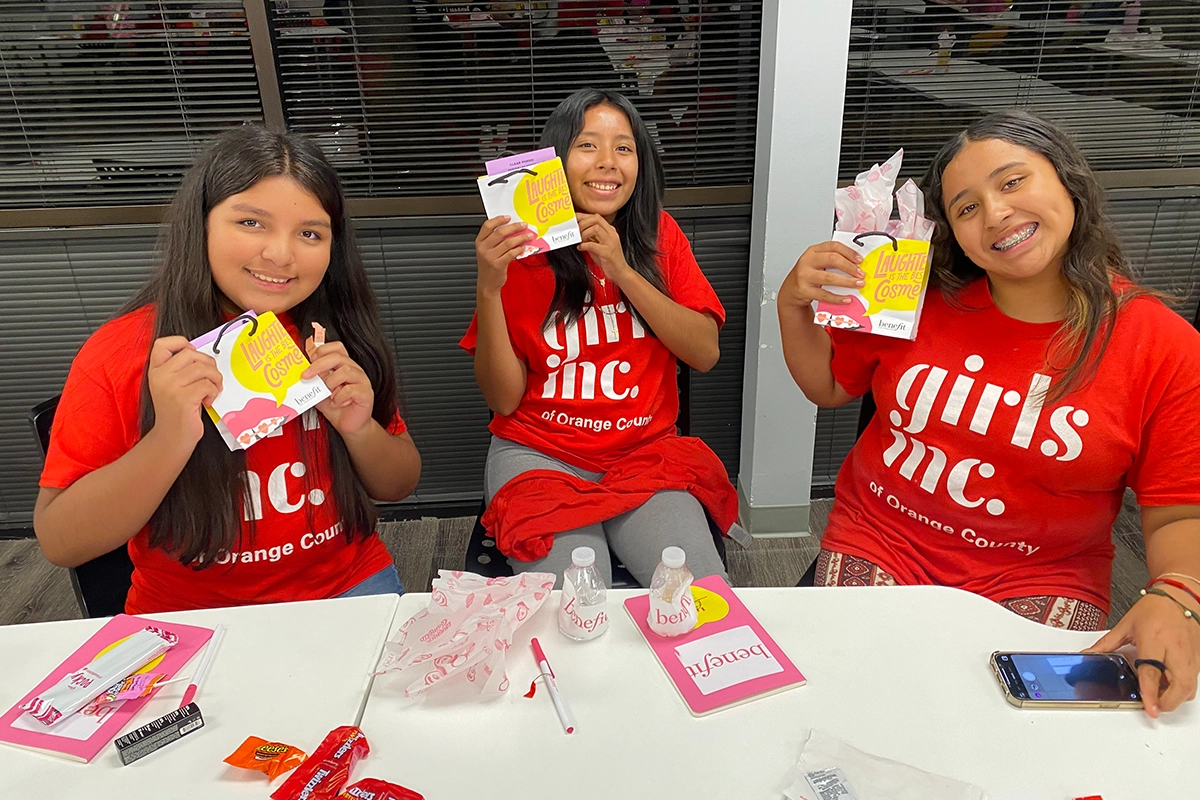 three-girls-smiling-holding-up-bags