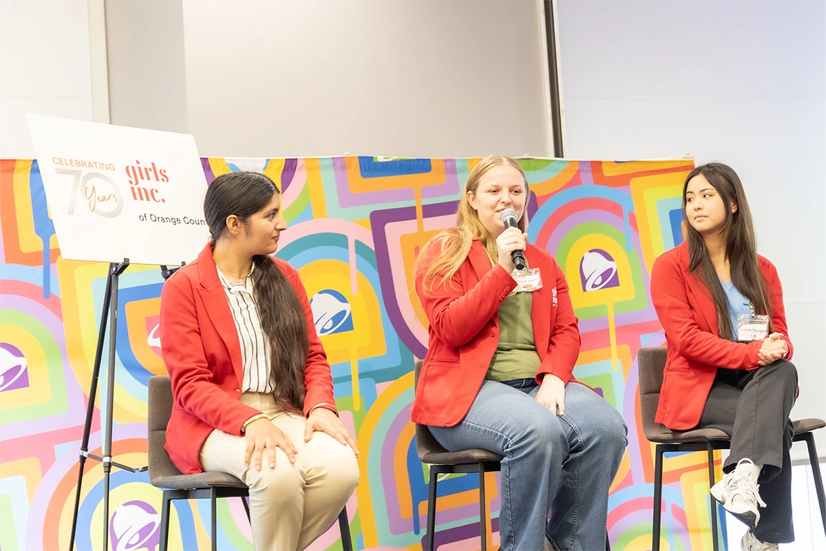 panel-of-three-girls-seated-on-chairs-one-with-microphone